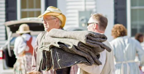 man carrying blankets
