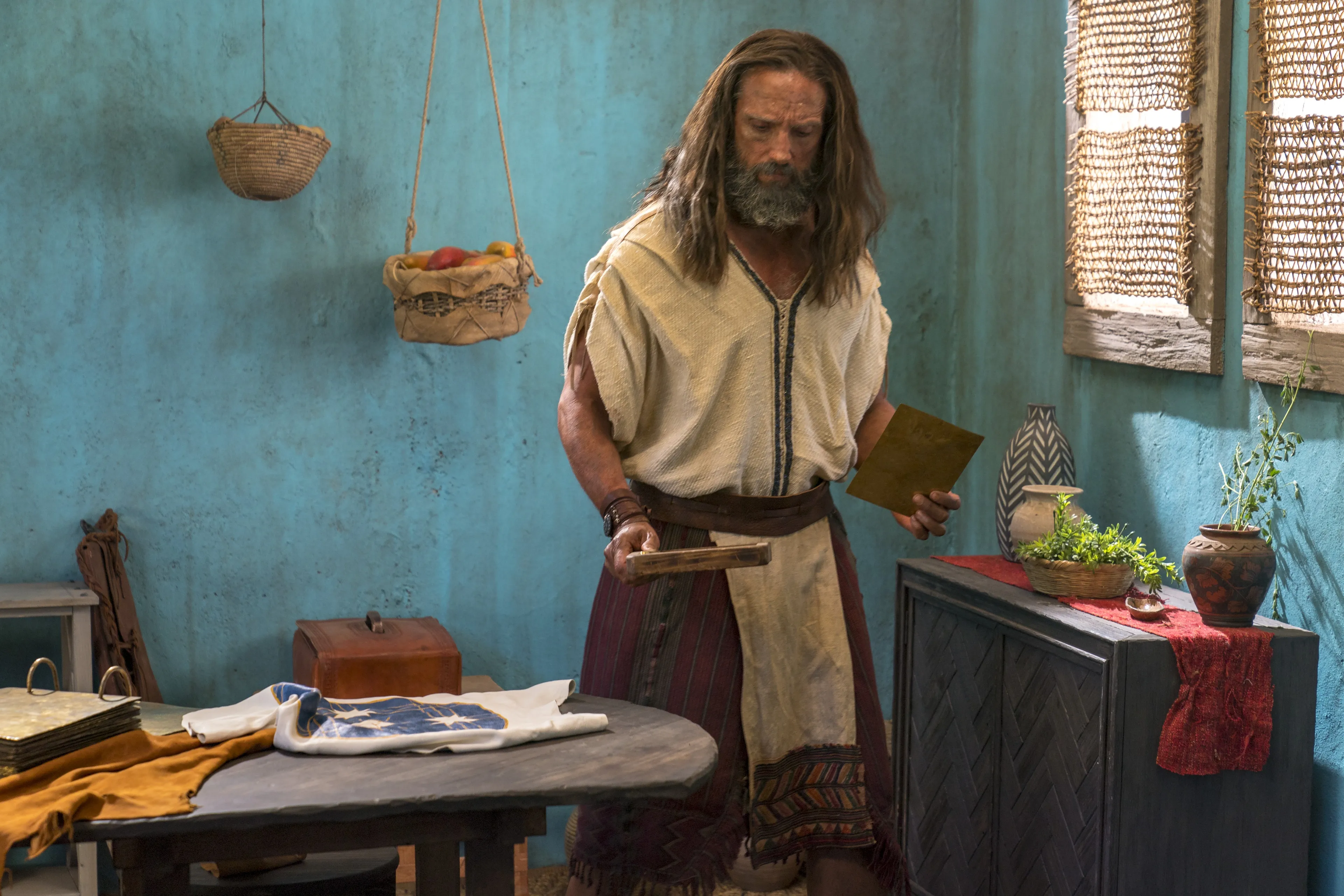 Nephi holds metal plates.