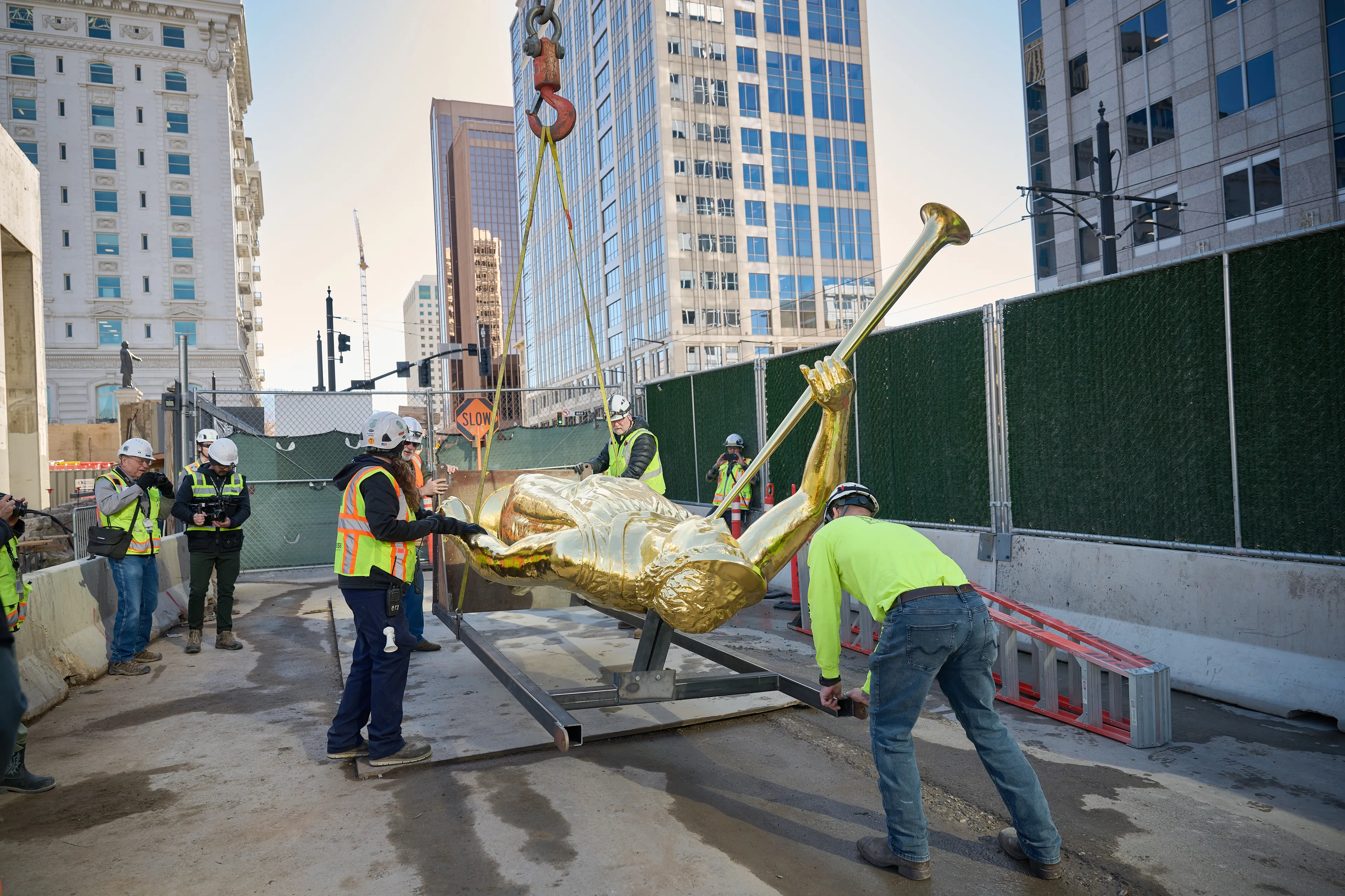 Construction workers lift Angel Moroni onto a crane before it is placed on top of the Salt Lake Temple during construction on April 2, 2024.