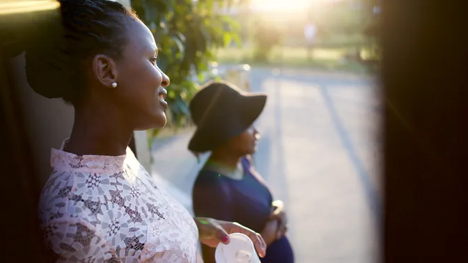South Africa.  Braai (or barbecue).  Two women standing outside near a gate.