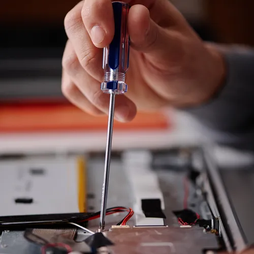 a person using a screwdriver to fix a computer
