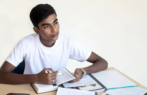 a young man studying his scriptures and pondering
