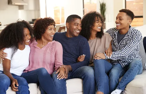 family sitting together on a couch and smiling