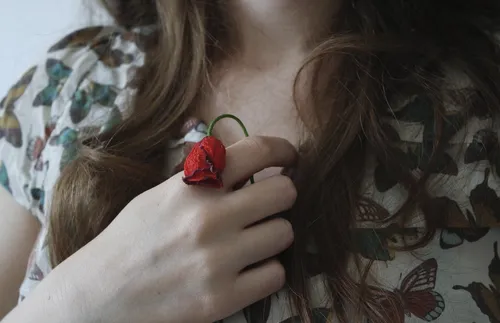 Woman holding rose to her chest