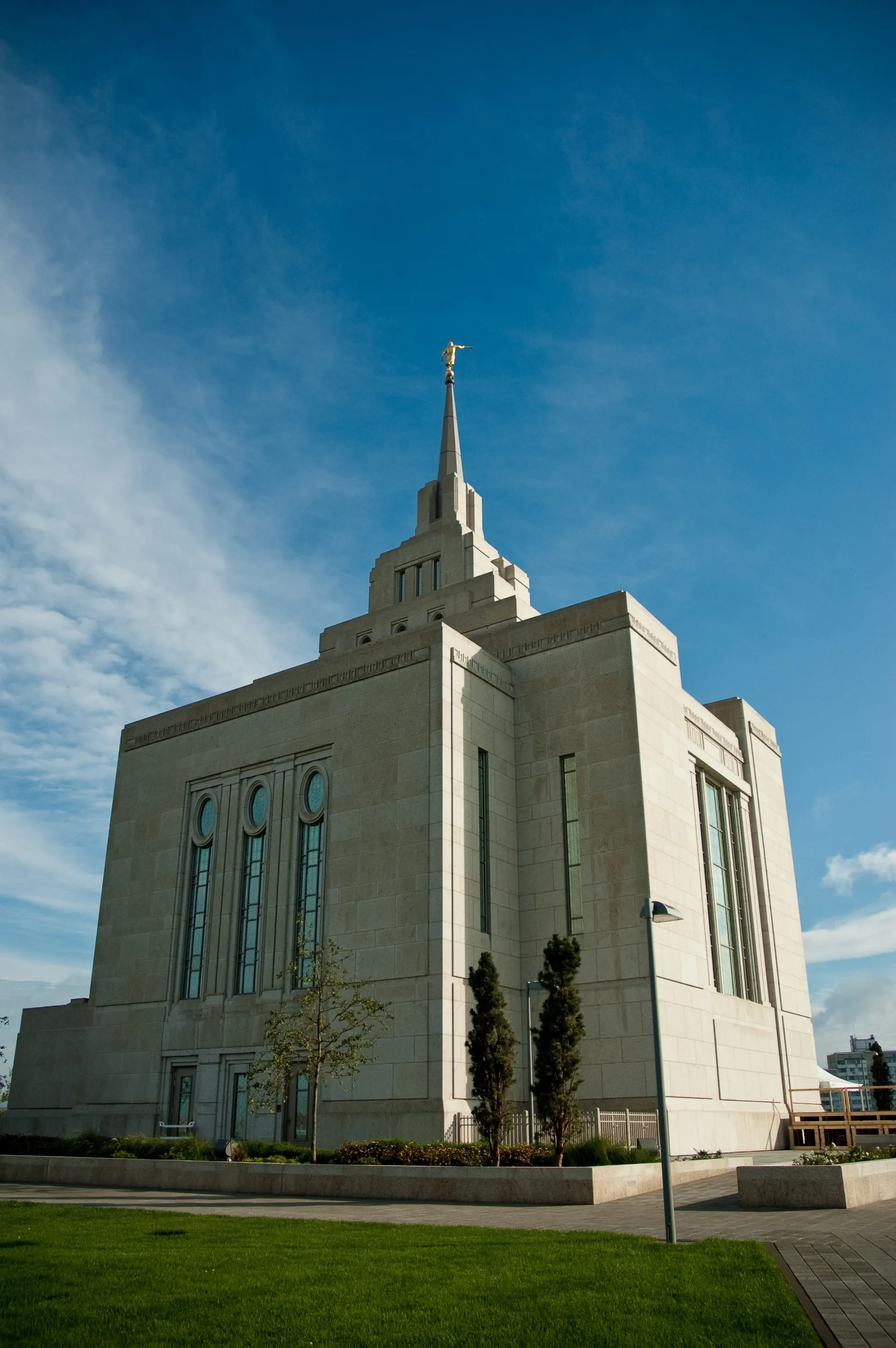 A side view of the Kyiv Ukraine Temple, including the windows, spire, and scenery.