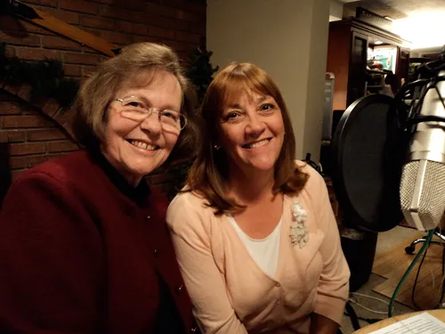 Two women (Kathy Madsen and Rosiland Hoggan) beside a radio microphone.