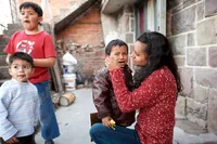 A mother tries to comfort her crying son.