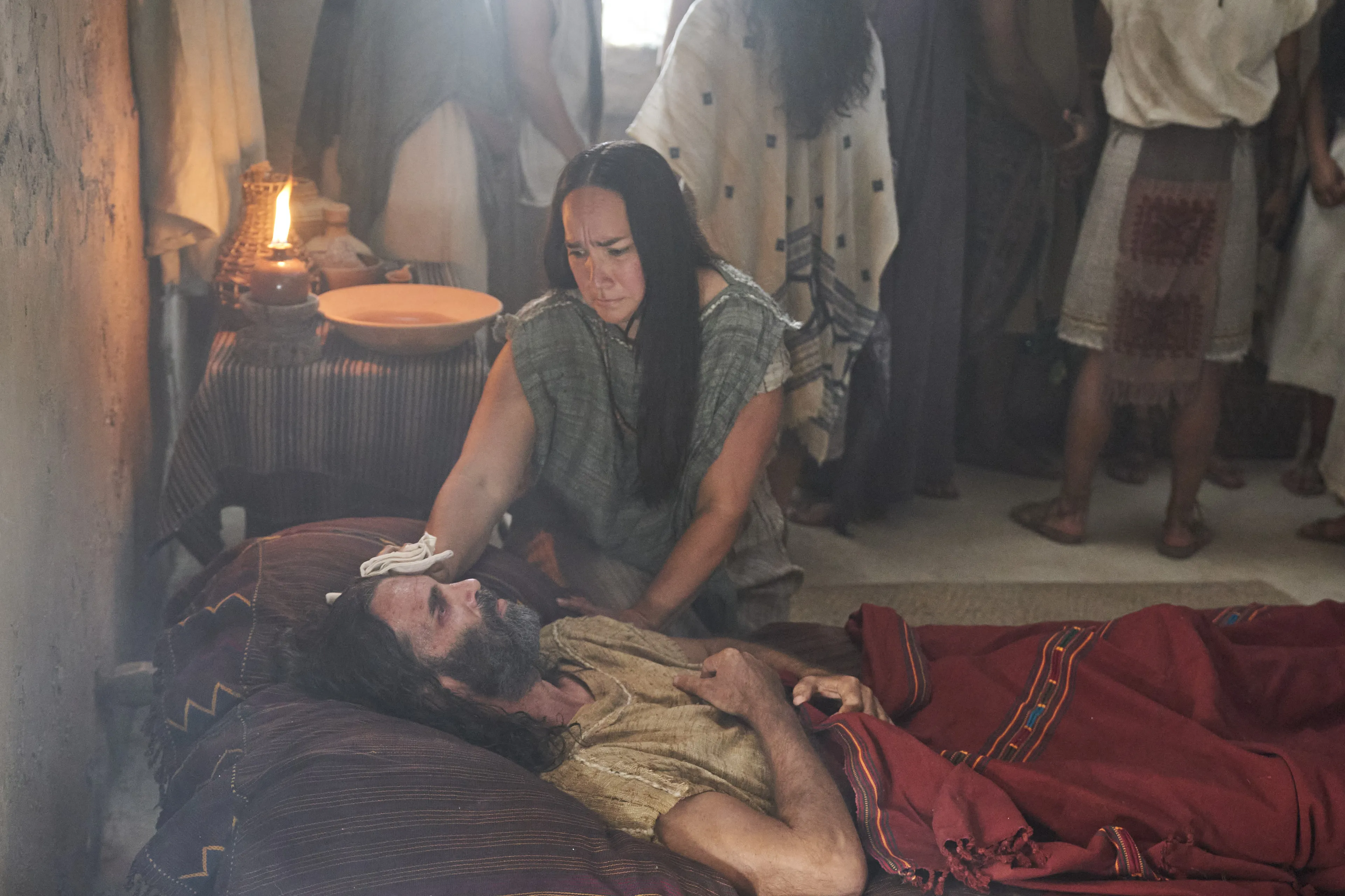 A woman attends to Zeezrom as he lays sick in bed in the land of Shilom.