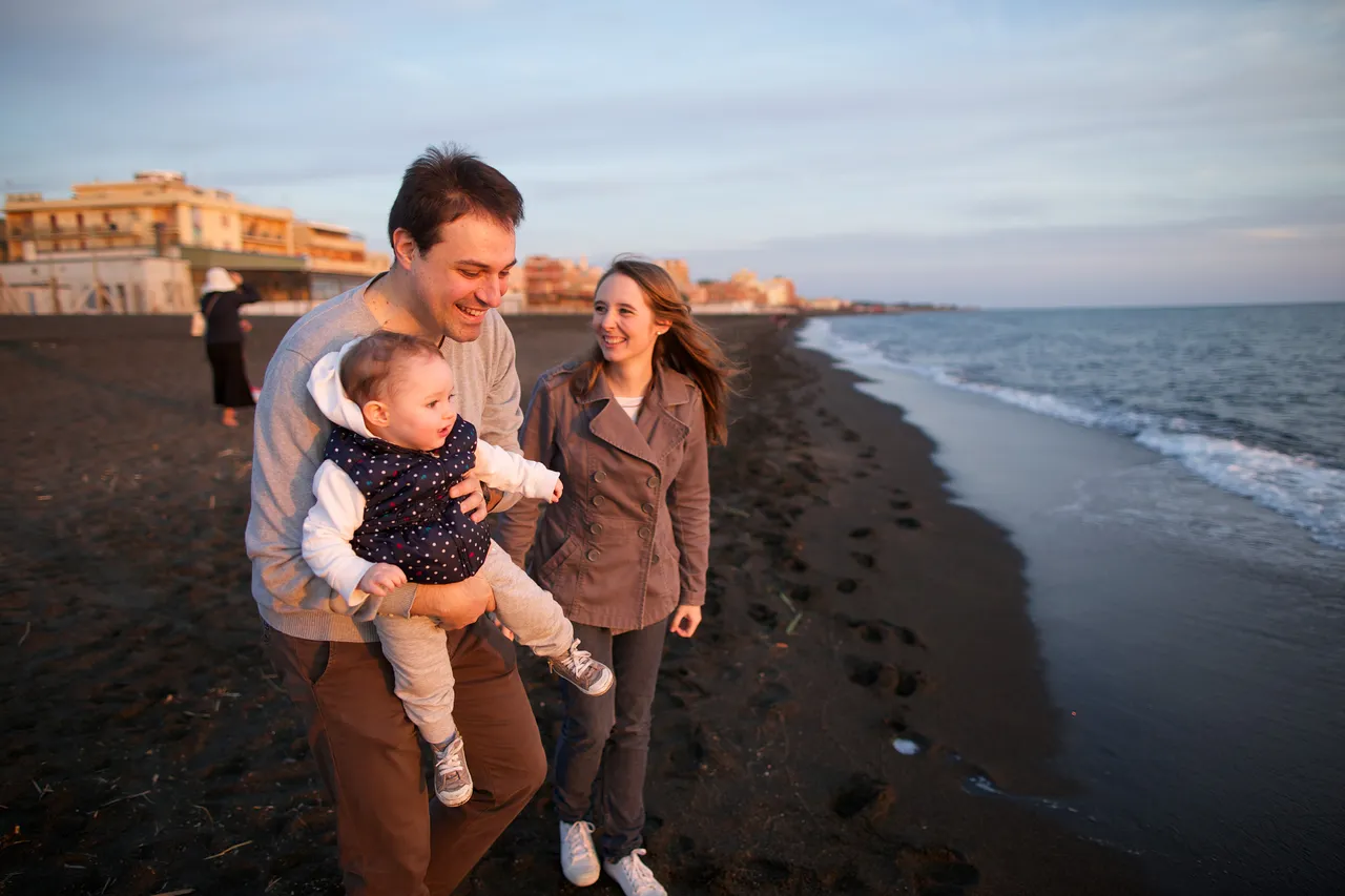 A family walks along the beach smiling
