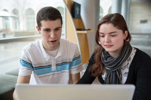 two young people using a computer
