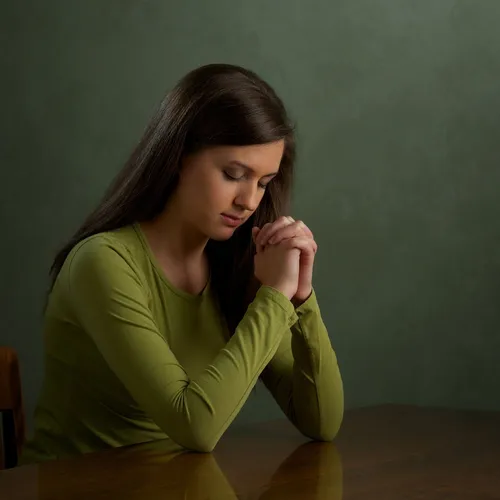 a woman bowing her head and praying