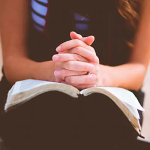 young woman with scriptures open on lap