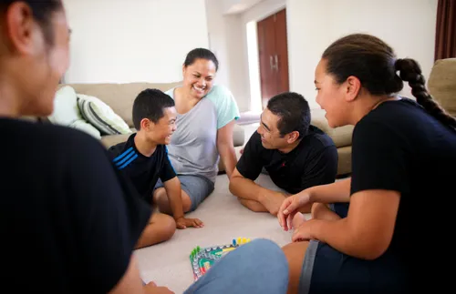 a family sitting on the floor and playing games together