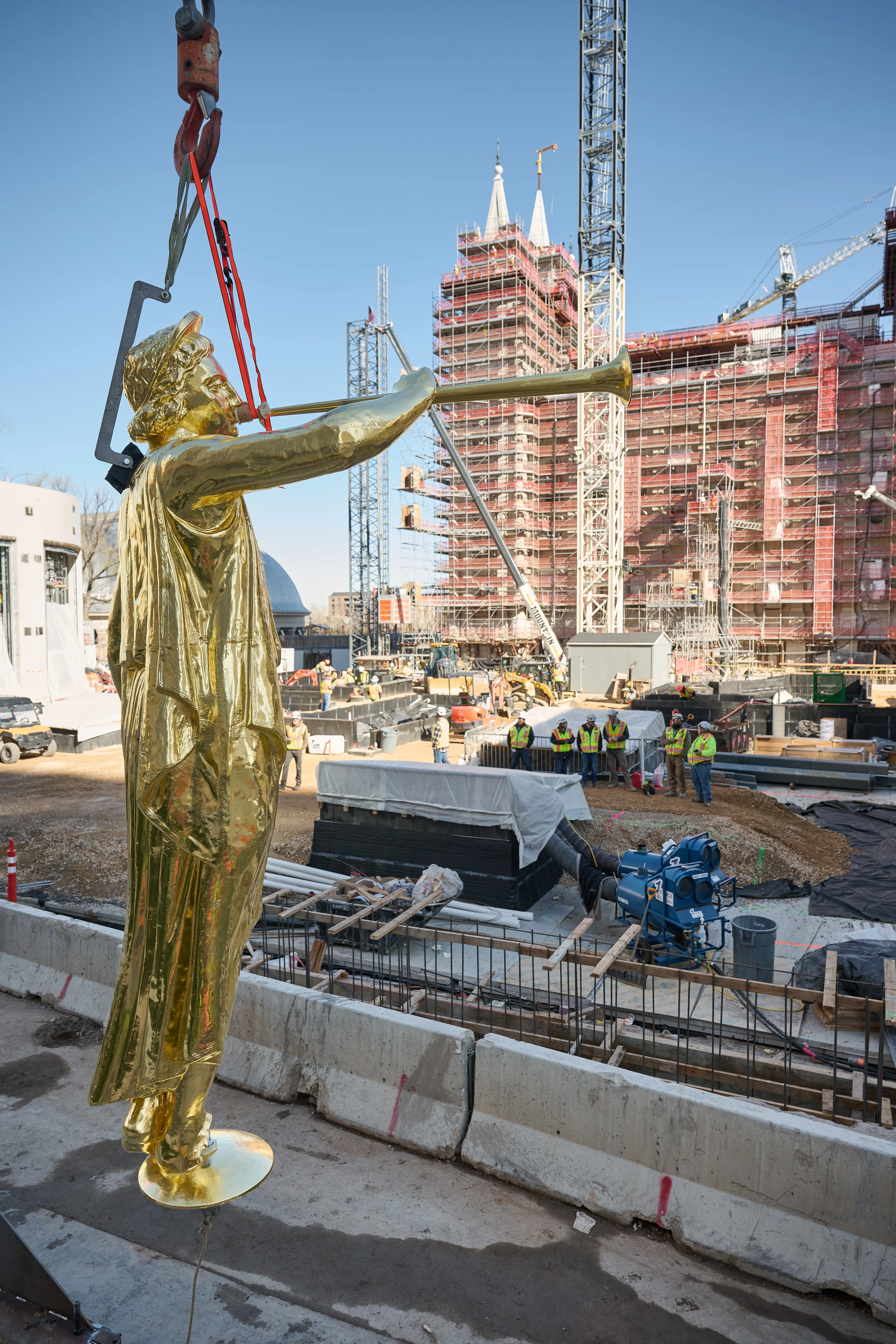 A crane lifts Angel Moroni to place it on top of the Salt Lake Temple during construction on April 2, 2024. A ceremony was held to celebrate the historic event.