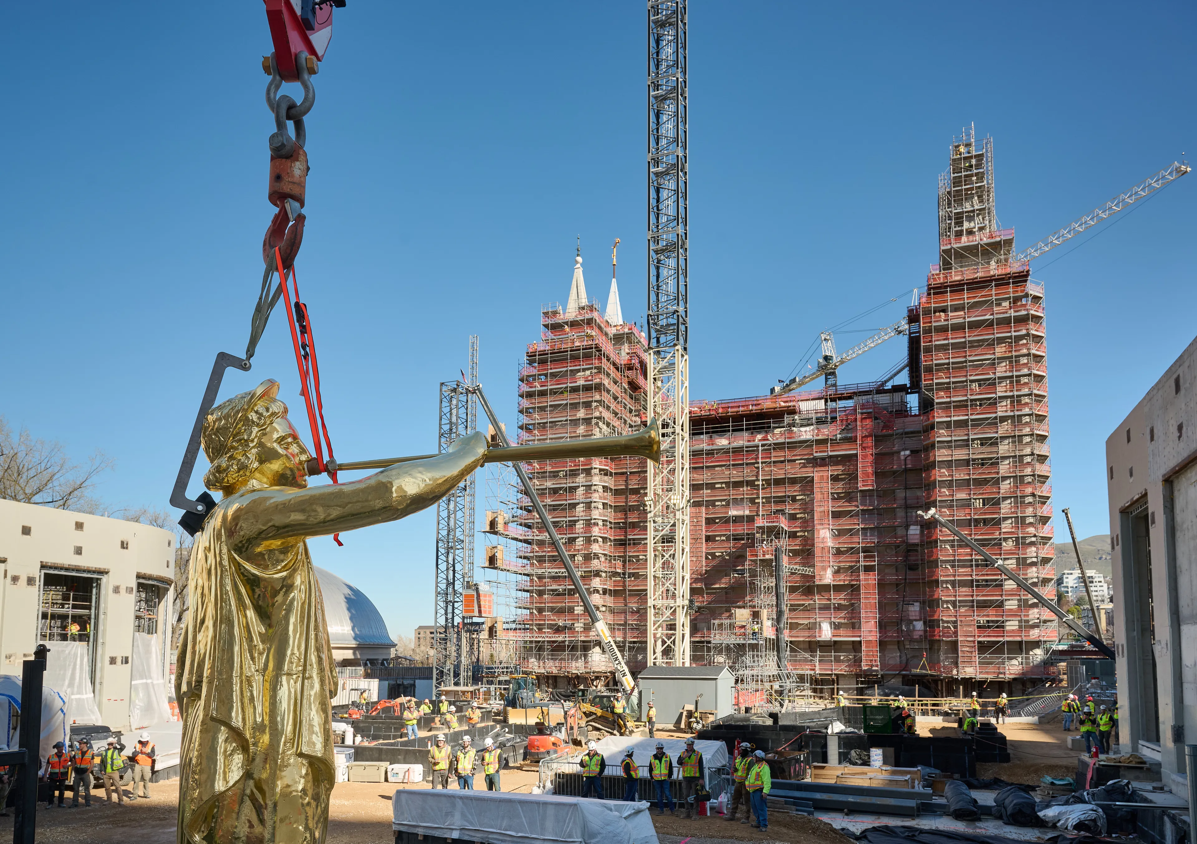 A crane lifts Angel Moroni to place it on top of the Salt Lake Temple during construction on April 2, 2024. A ceremony was held to celebrate the historic event.