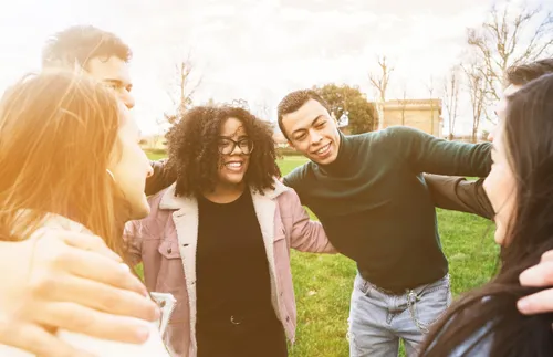 group of young adults hugging each other