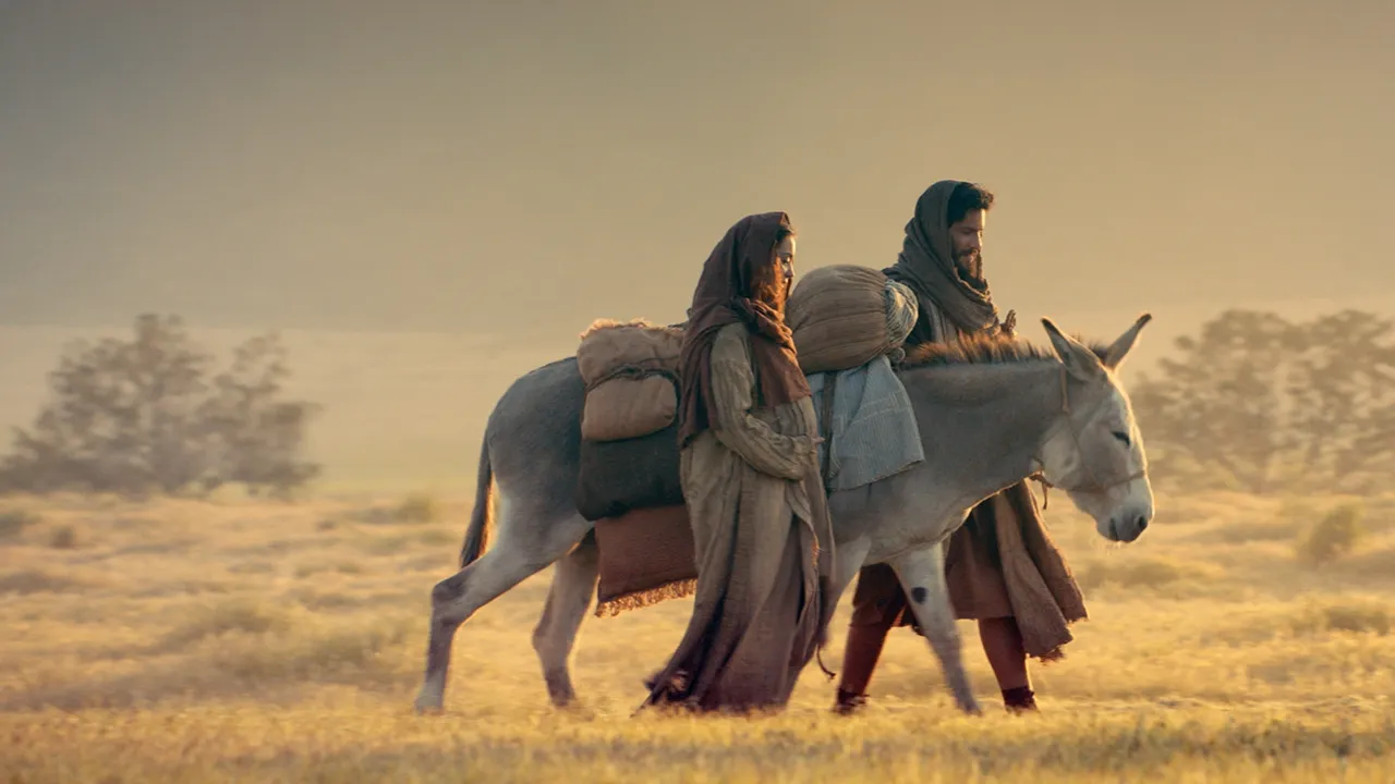 Mary and Joseph with a donkey travel to Bethlehem