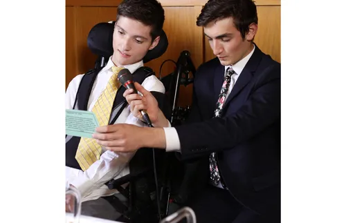 a young man in a wheelchair blessing the sacrament