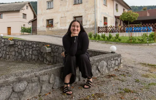 坐在石牆上微笑的婦女