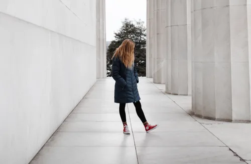 woman standing near marble pillars