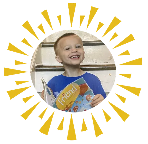 Smiling boy holding copy of the Friend magazine