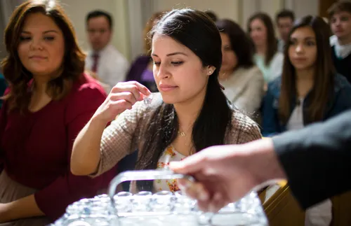 a woman taking the sacrament and pondering its significance