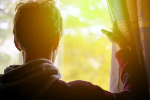 man looking out a window