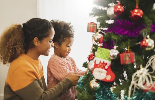 two girls decorating a Christmas tree
