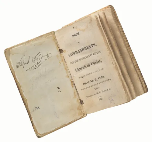 photograph of Book of Commandments open to title page, Wilford Woodruff signature on facing page