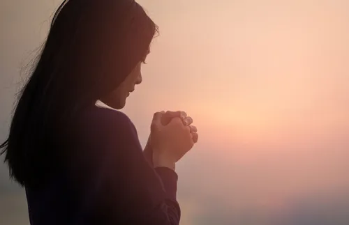 woman standing in front of a foggy sunrise