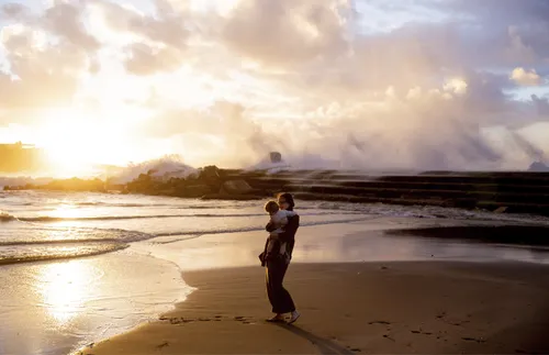 mother holding child on the beach