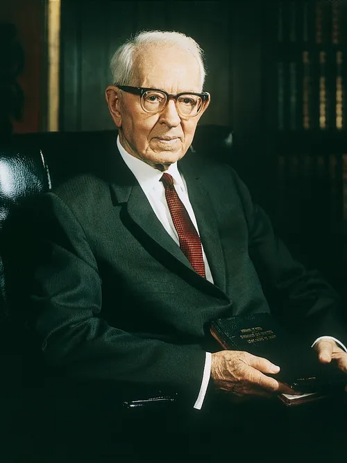 A portrait by Merrett T. Smith of President Joseph Fielding Smith sitting in a black chair.