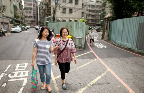 two women talking as they walk down a street