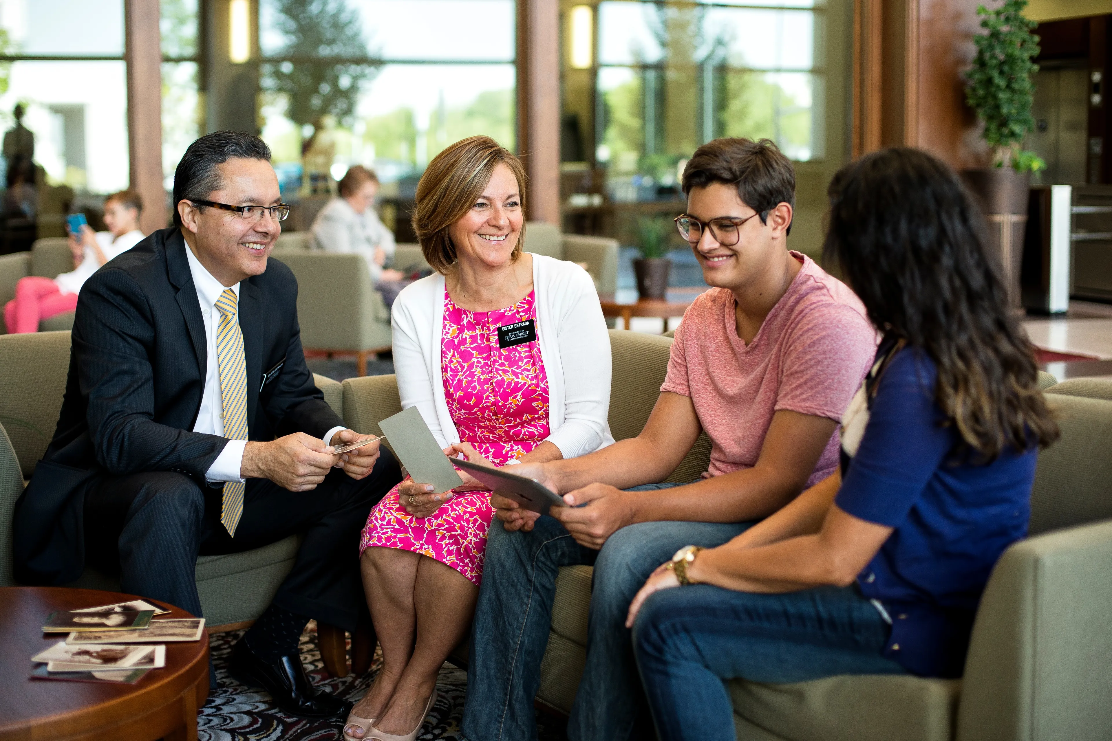 A senior missionary couple helps a young man and woman with family history.