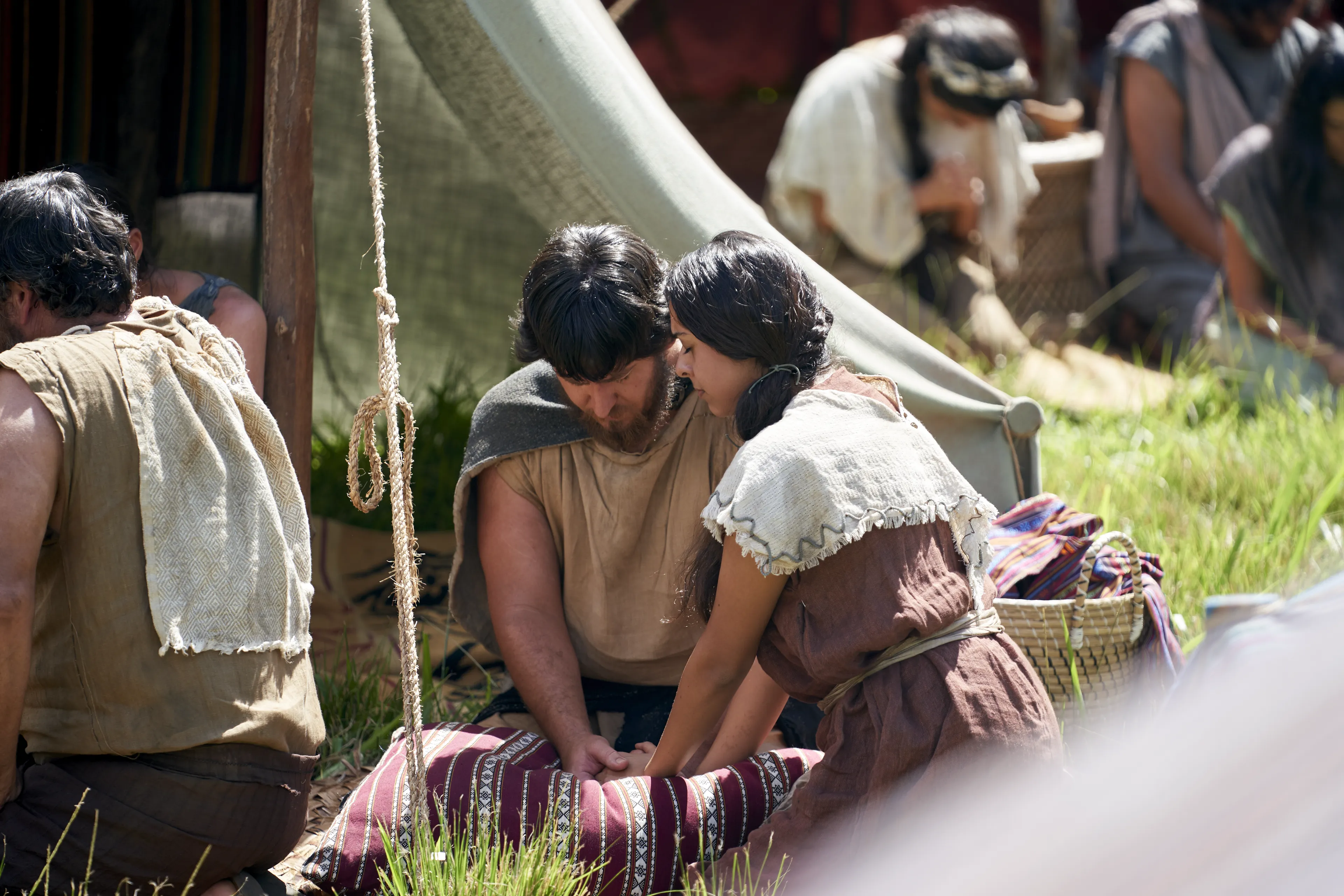 Men and women gather and kneel as they listen to King Benjamin in the Land of Zarahemla.