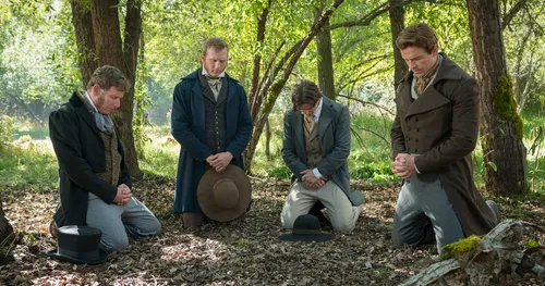 Re-enactment of four witnesses kneel in prayer in woods.