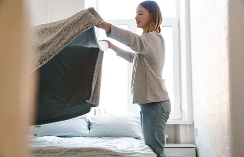 young woman making her bed