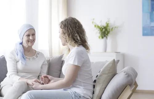 two women clasping hands and smiling at each other