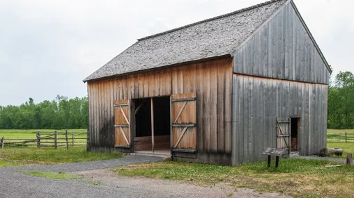 A large wooden barn with the doors wide open on the property of the Smith family farm in Palmyra, New York.