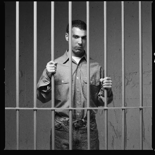 young man behind bars