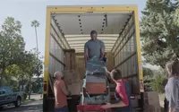 Neighbors help load a moving van for their neighbor