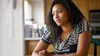 a thoughtful young woman sitting at a kitchen table