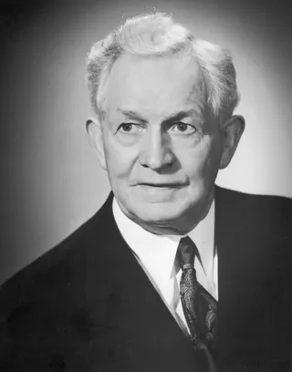 A black-and-white photograph of David O. McKay in a dark suit against a plain background.
