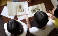 Two women look at family heirlooms at photos enjoying family history