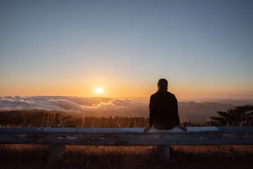 silhouette of young woman watching the sunset
