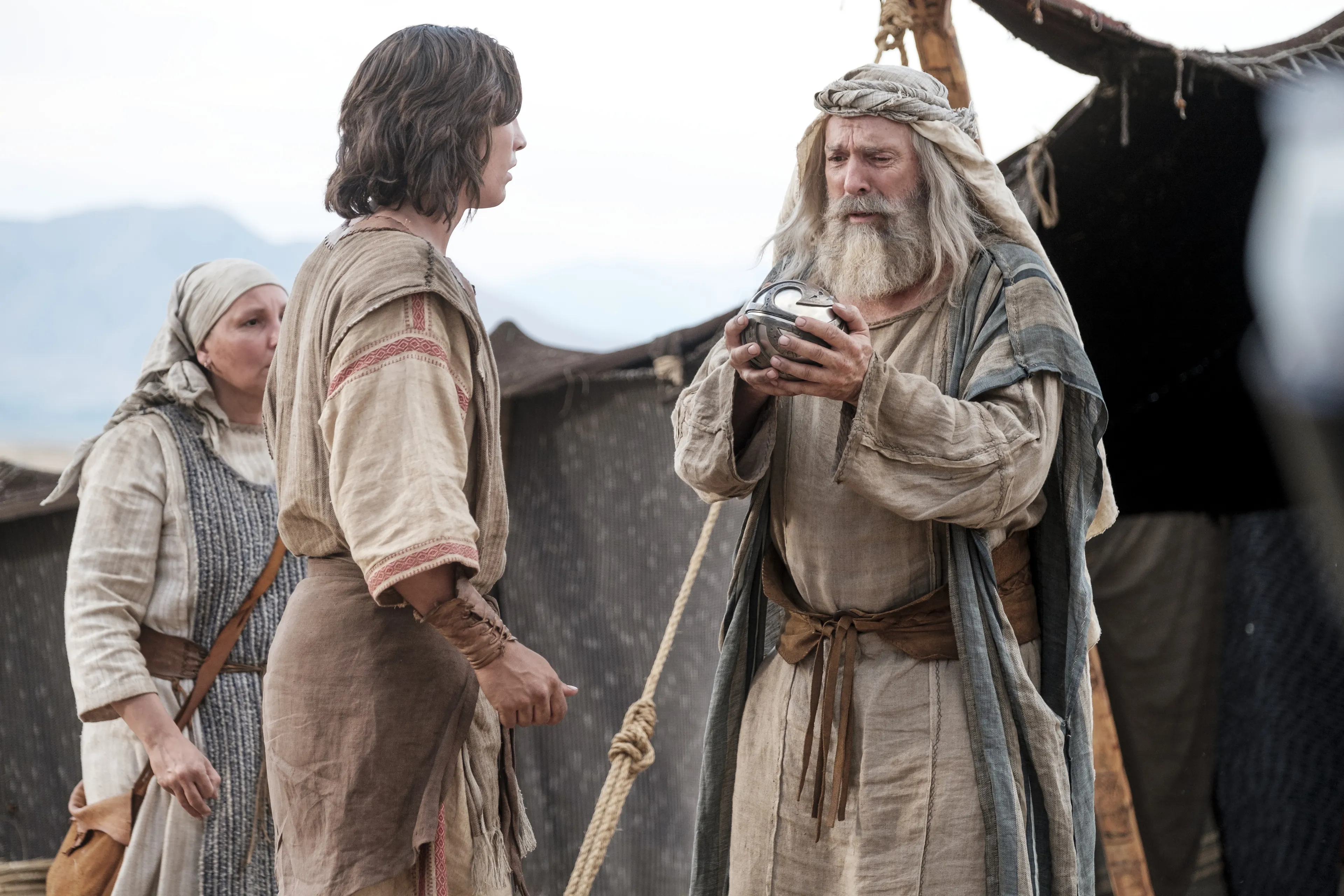 Lehi, Sariah, and Nephi look at the Liahona in the wilderness.