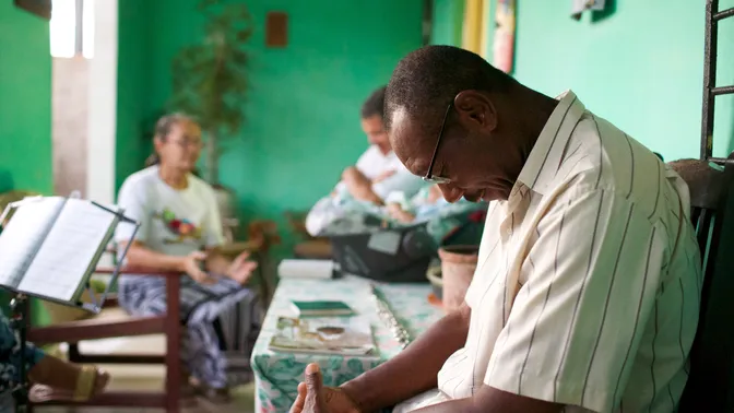 A family in Brazil doing various activities including: walking, talking, reading, studying, hugging, visiting with each other, playing games, taking selfie photos, playing with a baby, praying etc.