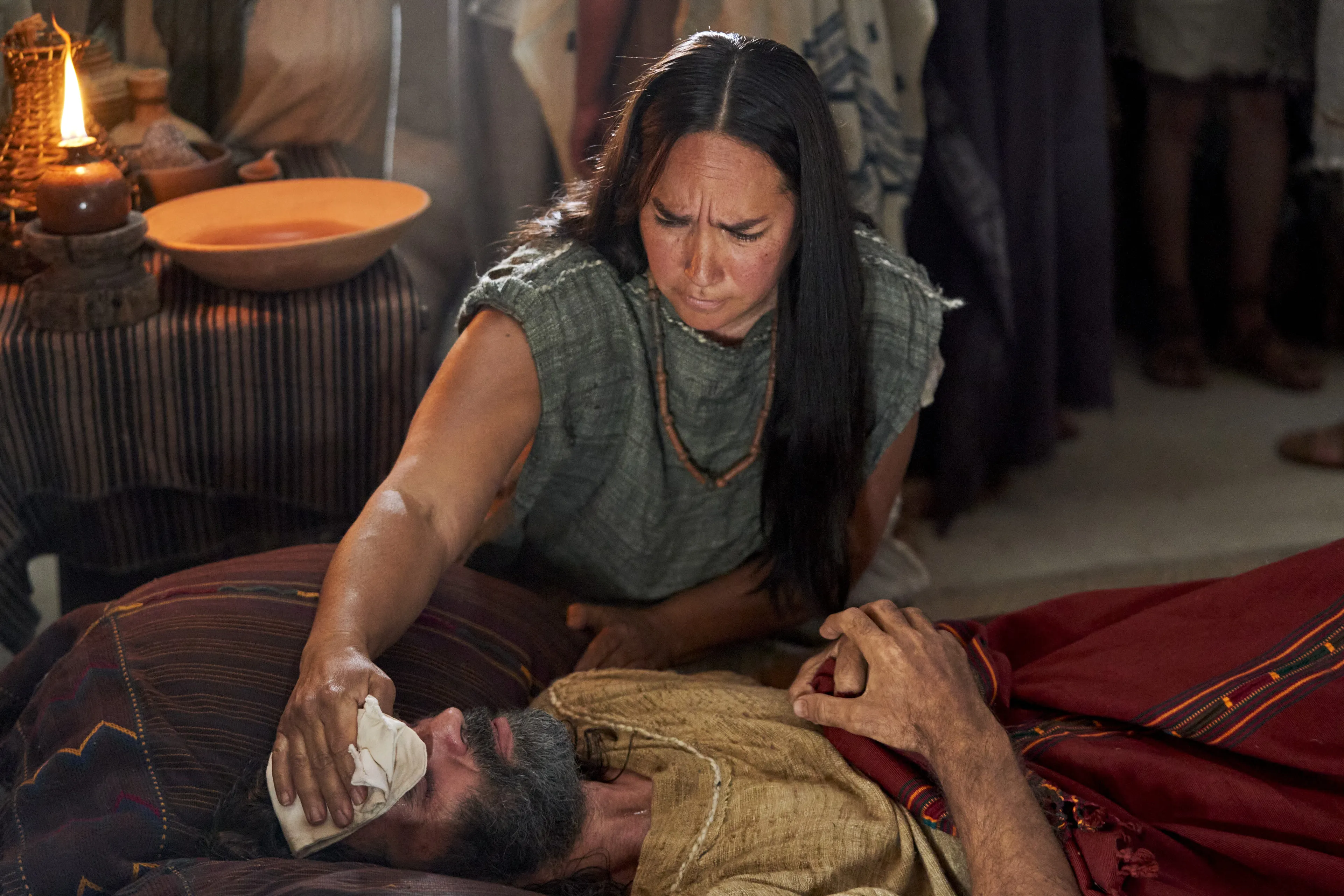 A woman attends to Zeezrom as he lays sick in bed in the land of Shilom.