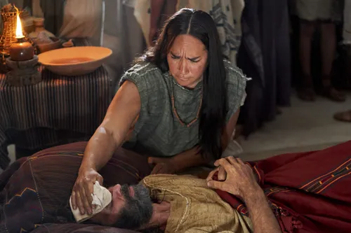 A woman attends to Zeezrom as he lays sick in bed in the land of Shilom.