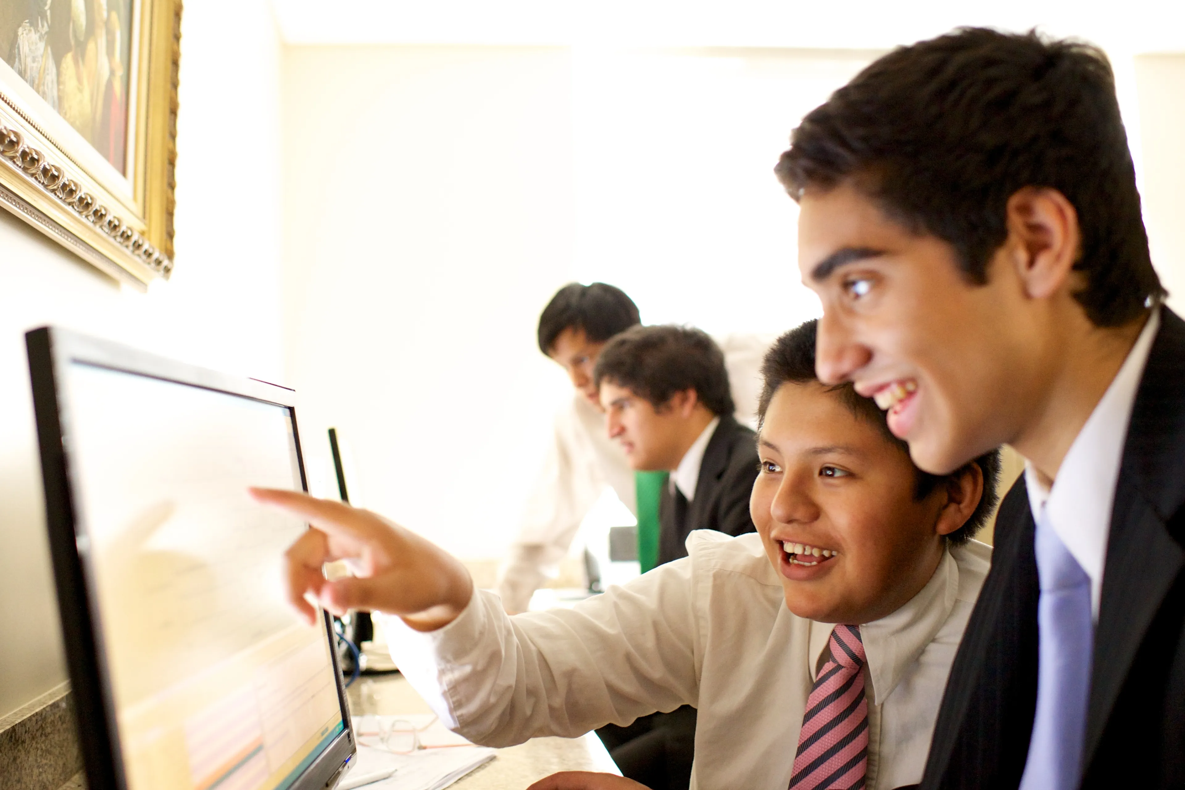 Young men looking at a computer together to do family history research.